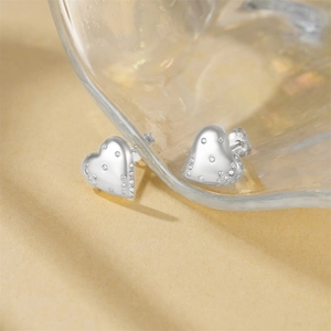 Macro shot of 925 silver heart stud earrings with sparkling pave zircon stones