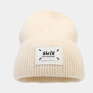 Minimalist beige ribbed knit beanie with SWiE logo patch for autumn and winter