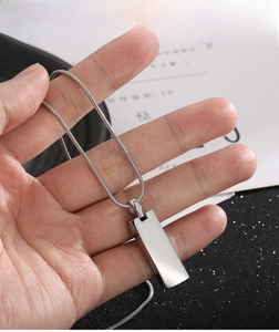 Detail of silver rectangular titanium pendant on snake chain with mirror finish luster