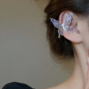 Macro view of purple gradient butterfly ear cuff with gold metallic outline on model