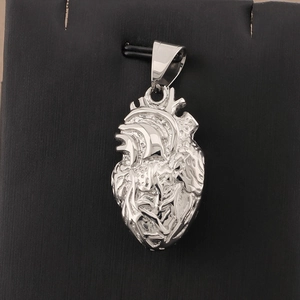 Detailed macro view of an anatomical heart pendant in polished silver stainless steel