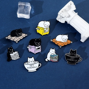 Macro view of 8 cute cat enamel pins including kittens in coffee cups and reading books