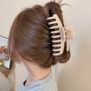 Detailed back view of a minimalist matte beige square claw clip securing a bun hairstyle
