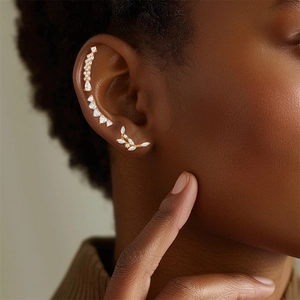 Detail of gold butterfly leaf ear cuffs with shimmering white cubic zirconia accents
