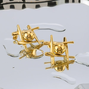 Polished 18k gold plated grid ball earrings on a reflective water surface background