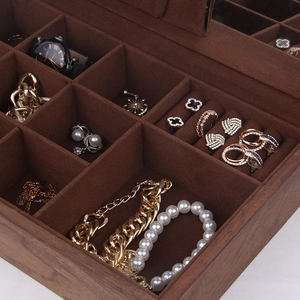Détail macro du coffret à montres en bois foncé avec compartiments en velours marron