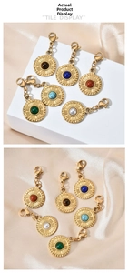 Macro detail of retro gold pendants with colorful stones on champagne silk fabric