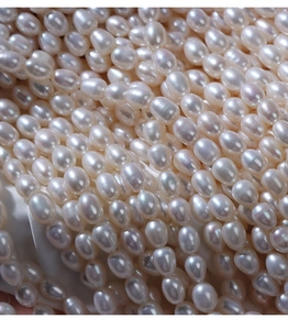 Macro view of 5-6mm white freshwater rice pearls with high luster for jewelry making