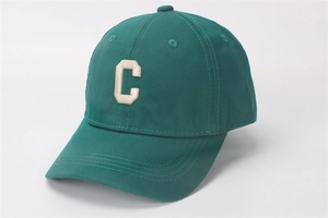 Gedetailleerd beeld van donkergroene baseballpet met wit geborduurde letter C op katoen