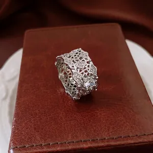 Luxe silver grid hollow ring with zircon stones shown on a brown leather stand