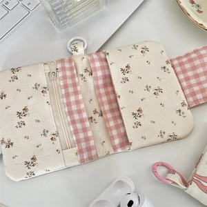 Floral fabric wallet with card slots and zipper closure on a white desk setup