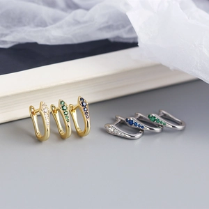 Detailed view of U-shaped snake design earrings with colorful zircon in gold and silver