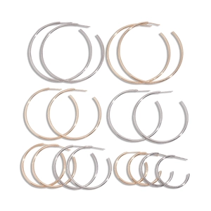 Minimalist geometric round hoop earrings set in polished gold and silver metal finishes