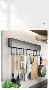 Detail of dark grey metal kitchen rail with sliding hooks for hanging utensils