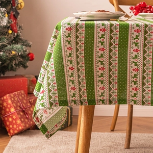 Christmas tablecloth with red green reindeer and snowflake patterns on wooden table