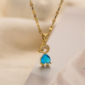 Detailed close-up of golden duck pendant with blue heart zircon and pavé accents