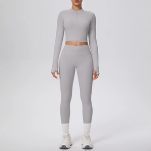 Vue de face de l'ensemble de yoga gris clair avec veste zippée à passe-pouce et legging