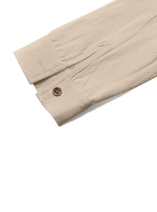 Close-up of beige linen shirt cuff showing breathable fabric texture and vintage button