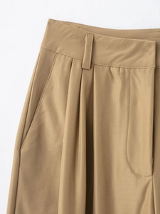 Detailed macro view of khaki pleated trouser waist with fine twill texture and stitching
