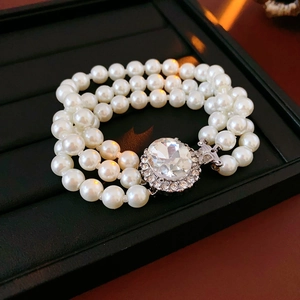 Dettaglio del bracciale a tre file di perle con grande fibbia ovale incastonata di diamanti