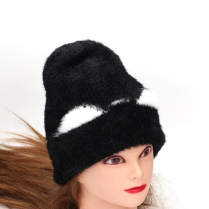 Close-up of black faux fur knit hat featuring plush cat ear design and white patches