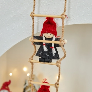 Close-up of a Christmas doll in red hat and black dress climbing a wooden rope ladder