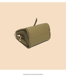 Detail view of olive green pebbled leather bucket bag with premium gold zipper accents