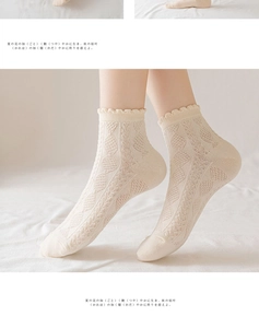 Detail of beige crew socks featuring hollow lace floral patterns and wavy ruffled edges