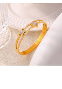 Detail of gold double-layered bangle featuring star charms and sparkling zircon inlay