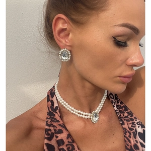 Close-up of model wearing retro pearl layered necklace and oval rhinestone earrings set