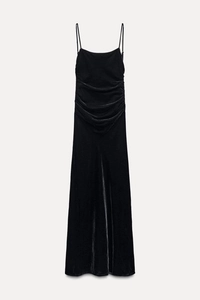 Detailed view of black velvet midi dress showing ruching detail and thin spaghetti straps