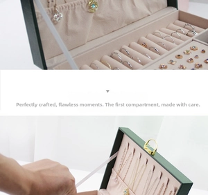 Close-up of dual-layer jewelry box with necklace hooks and emerald leather texture
