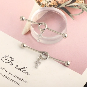 Detailed close-up of silver industrial barbell earring with crystal cross pendant