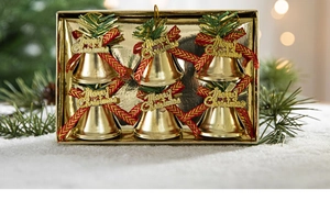 Close-up of 6 golden Christmas bells with red ribbons and pine needles in a gift box
