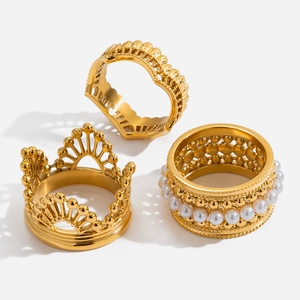 Dettaglio di un set di anelli a corona in oro 18K con perle sintetiche e strass lucidi