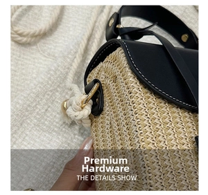 Close-up of golden metal buckle and black leather flap on a woven straw handbag