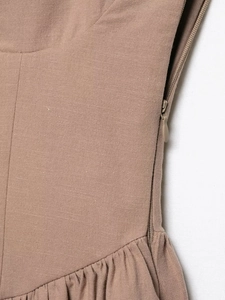 Detail of brown cotton linen dress with invisible side zipper and pleated fabric texture