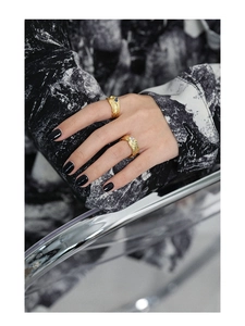 Macro detail of irregular lava texture gold rings with blue and clear zircon stones