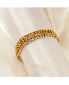 Macro detail of gold triple-layer chain bracelet with sparkling rhinestones on silk