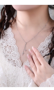Close-up of elegant S925 silver Y-shaped tassel necklace with sparkling cross pendant