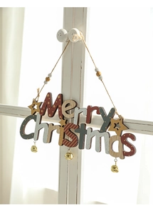 Close-up of Merry Christmas wooden hanging plaque with festive bells on a white window