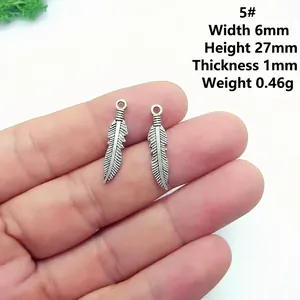 Detail of vintage silver feather charms showing dimensions 6x27mm for DIY jewelry