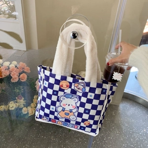 Detail der blau-weiß karierten Canvas-Tasche mit Plüschgriff und süßem Bären-Druck