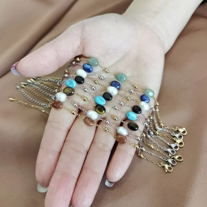Detailed close-up of bohemian gemstone bracelets with pearls and gold stainless steel chains