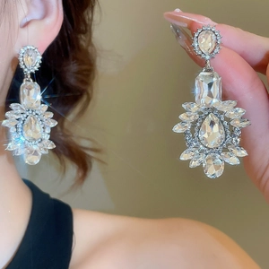 Macro shot of silver drop tassel earrings with sparkling crystals and model wearing style