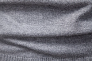 Close-up of the grey knitted fabric texture showing premium wool yarn details