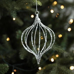 Silver hollow glitter star Christmas tree ornament hanging on a festive branch