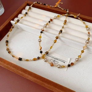 Detail of vintage beaded tiger eye necklaces with amber resin and gold pearls