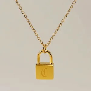 Close-up of gold padlock pendant featuring a gothic letter D on a fine chain