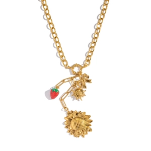 Detailed shot of chunky gold chain necklace with strawberry and sunflower pendants